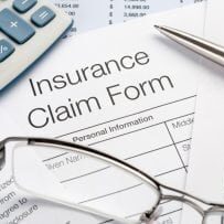Close up of Insurance Claim Form with pen and calculator